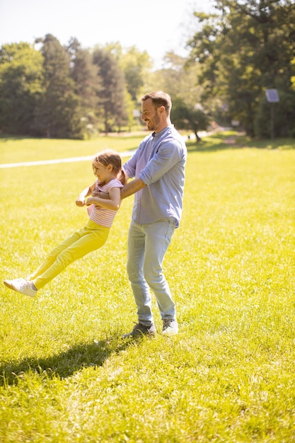 Father with daughter having fun on the grass at the park