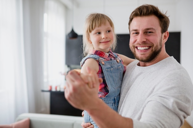 Photo father with daughter looking at camera