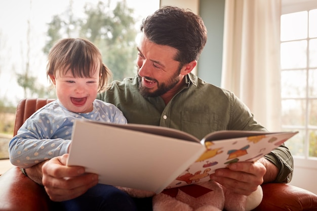 Photo father with down syndrome daughter reading book at home together