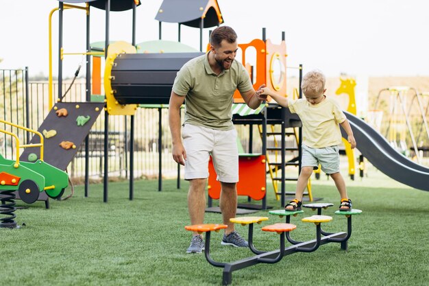 Отец с сыном играют на детской площадке