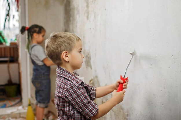 Father with kid repairing room together and painting the wall together