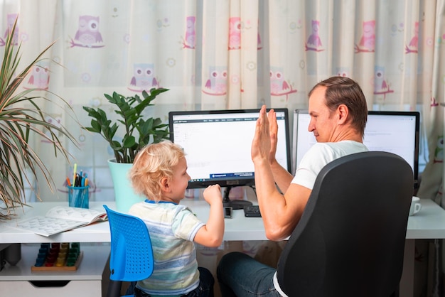 検疫中に自宅で仕事をしようとしている子供を持つ父親コロナウイルス中に自宅で仕事をするという概念