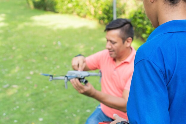 Father With Son Flying Drone In Forest