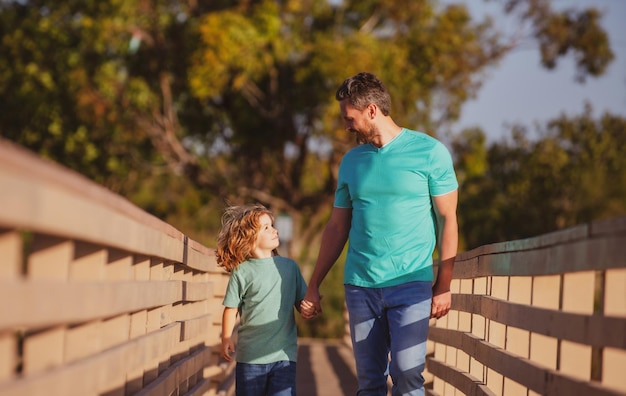 Father with son walking on wooded bridge outdoor