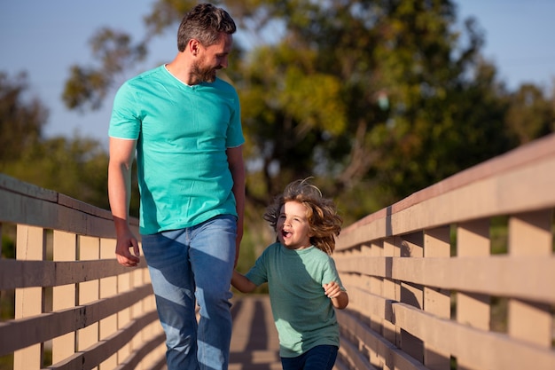 Father with son walking on wooded bridge outdoor