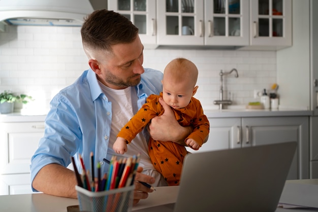 Photo father working from home trying to balance family life with child and job