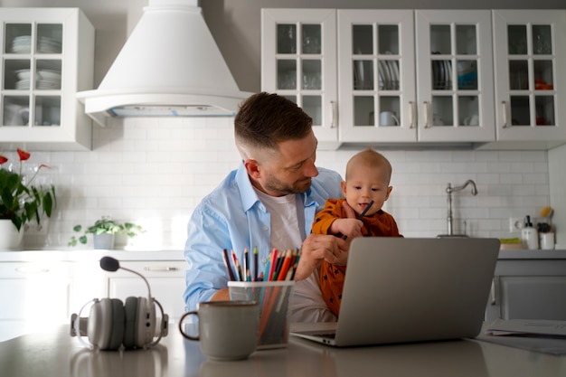 Father working from home trying to balance family life with child and job