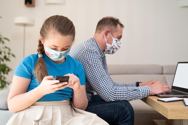 Father working remotely on notebook while taking care of his child teenager helps his dad while work