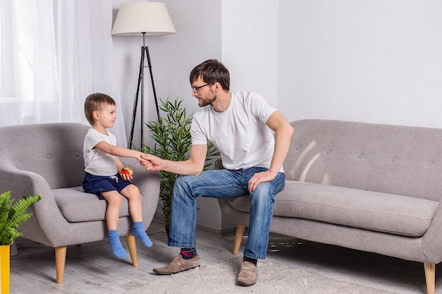 Father and young son discussing something serious in the living room at home Family of trust