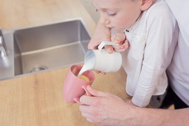 A father and young son make coffee in the morning