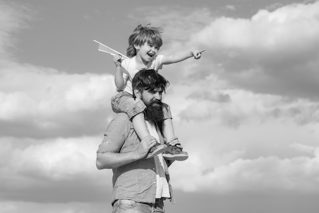 父の日屈託のない幸せな家族の父と子が自然の夏に凧と牧草地で