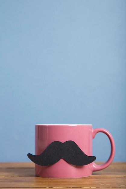 Fathers day coffee mug with a paper mustache against a blue background