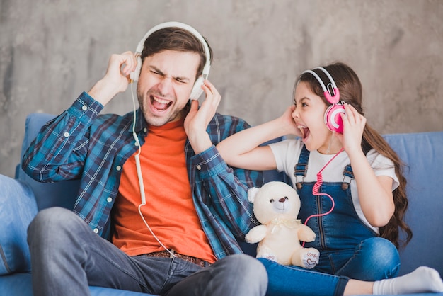 Concetto di giorno di padri con padre e figlia ascoltando musica