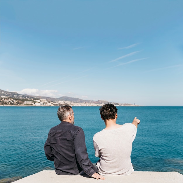 Foto concetto di giorno di padri con padre e figlio, guardando verso il mare