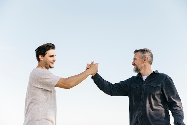 Photo fathers day concept with son and father shaking hands