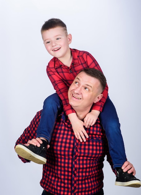 Fathers day father example of noble human father little son red\
shirts family look outfit best friends forever dad piggybacking\
adorable child having fun happiness being father of boy