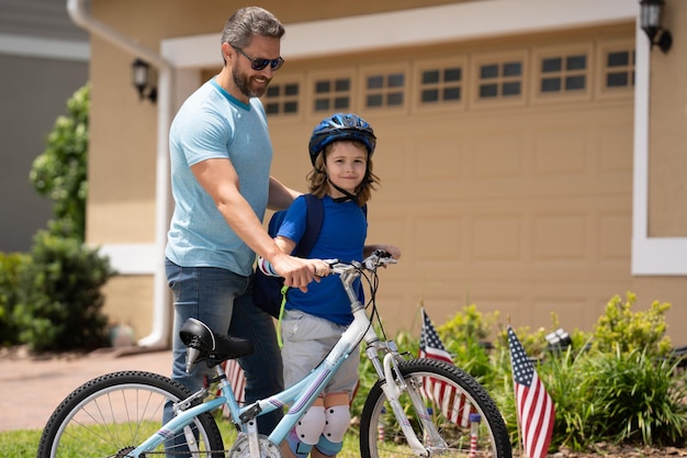 父の日 息子に自転車に乗ることを教える父 夏の日に自転車でサイクリングする父と息子 父の日