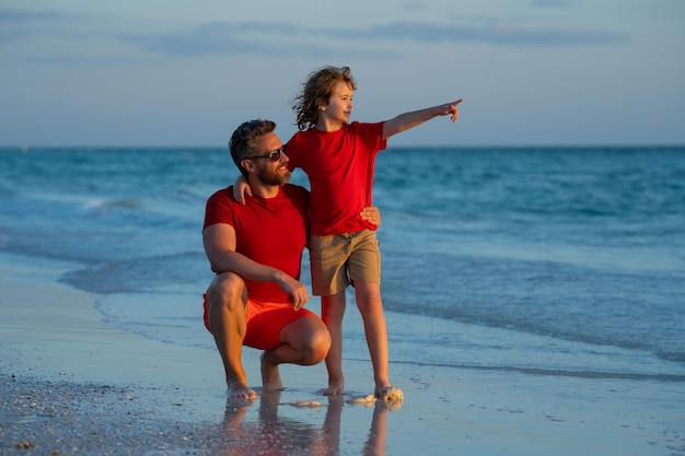 Fathers day father walking with a little child son on beach near sea dad with son walking on a summe