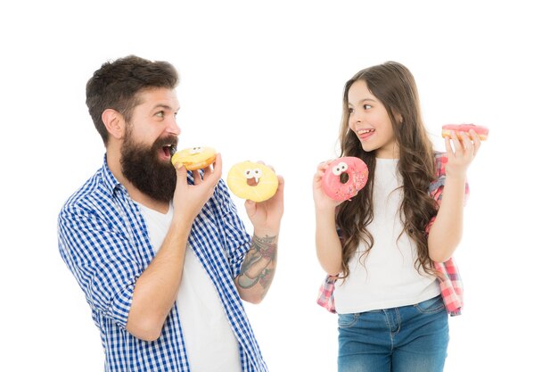 Fathers day present Perfect for dads with sweet tooth Girl child and dad hold colorful glazed donuts Sweets and treats concept Daughter and father eat sweet donuts Sweet dessert We love donuts