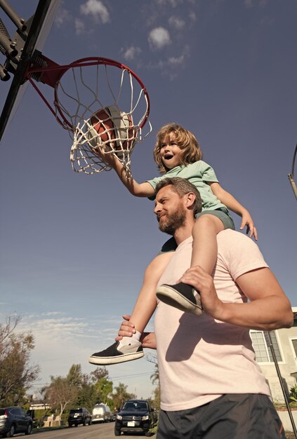 Fathr and son play basket ball outdoor on sport playground sport