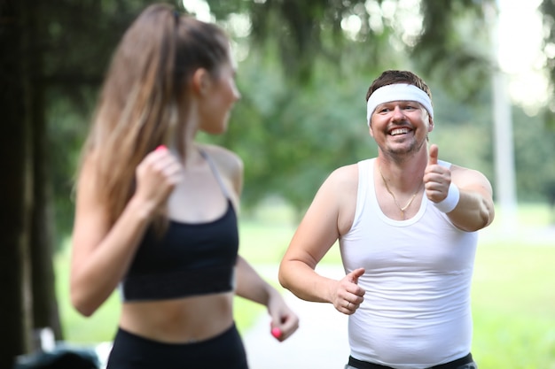 Fatty millennial man running in park with