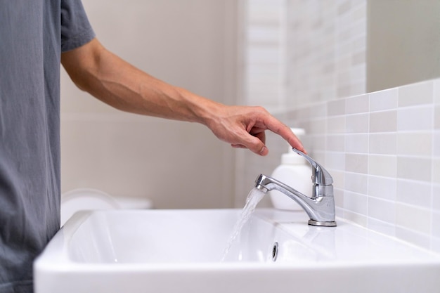 The faucet in the bathroom with running water Man keeps turn off the water to save water energy and protect the environment save water concept