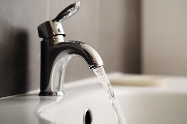 faucet with turned drop water in modern bathroom Horizontal crop with shallow depth of field