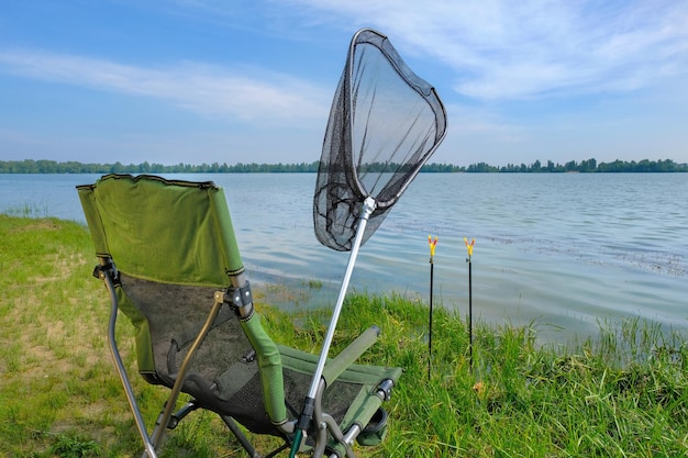 Fauteuil en visnet op de rivieroever vissende achtergrond