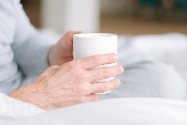 Favourite comfort beverage. Healthy habit. Man hands with cup of hot drink. Close up.