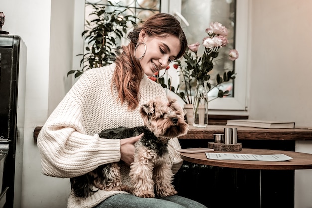 Photo a favourite pet. a woman happily holding her small dog