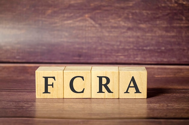 木製のテーブルに木製のブロックに書かれた FCRA 公正信用報告法単語
