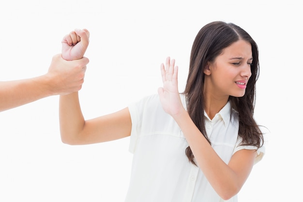 Fearful brunette being grabbed by the hand