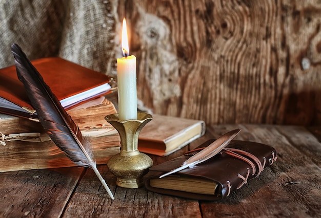 Feather and book novel close to the a candle