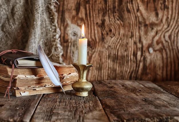 Feather and book novel close to the a candle