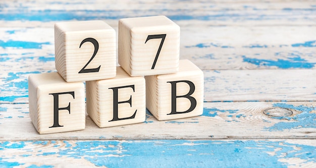 February 27th. Wooden cubes with date of 27 February on old blue wooden background.