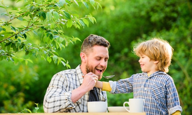 Feed son solids Feed your baby Natural nutrition concept Dad and cute toddler boy having lunch outdoors Child care Feeding son natural foods Feed in right way for childs stage of development