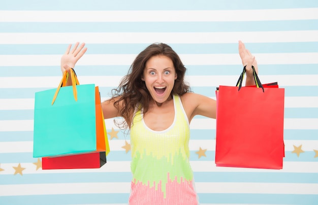 Feel free buy everything you want. Woman carries bunch shopping bags striped background. Finally bought favorite brand. Tips shop sales. Girl satisfied with shopping. Profitable purchase black friday.