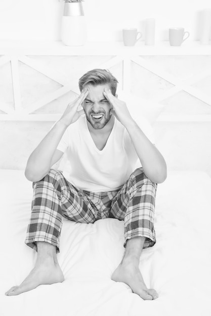 Feel pain and stress need more time to sleep Menswear pajamas Pajamas for home relax male feeling sleepy stressed man sit in pajama man relax in bed hard morning wakeup man has headache