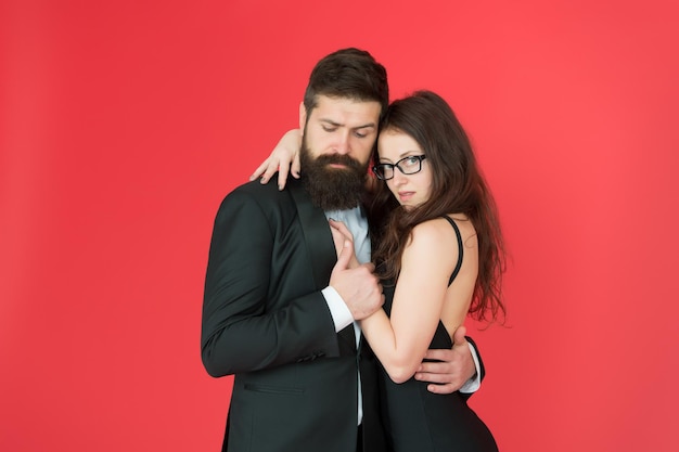 Feel rhythm of heart Happy together Man in tuxedo and woman black dress dancing at party Passionate couple dancing Lets dance tonight Elegant couple in love tender hug dancing red background