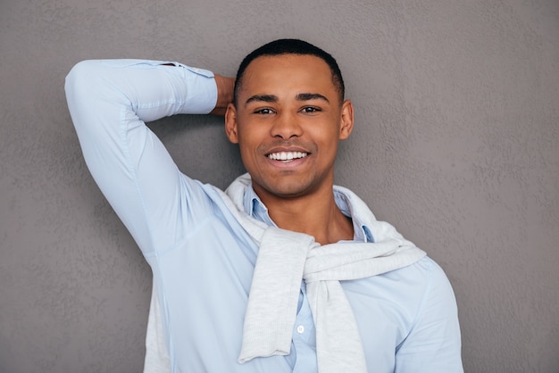 Feeling confident in his style. Confident young African man holding hand behind head