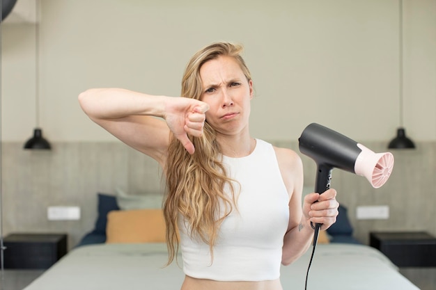 Photo feeling crossshowing thumbs down hair dryer concept