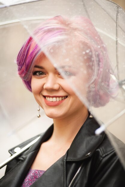 Feeling dry and protected Attractive young woman carrying umbrella and smiling