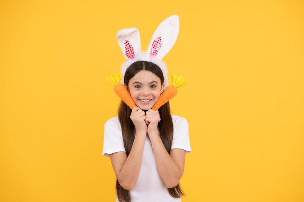 Feeling excited child in rabbit ears and bow tie time for fun\
adorable kid looking funny with carrot paschal spring holiday happy\
teen girl wear bunny ears happy easter childhood happiness