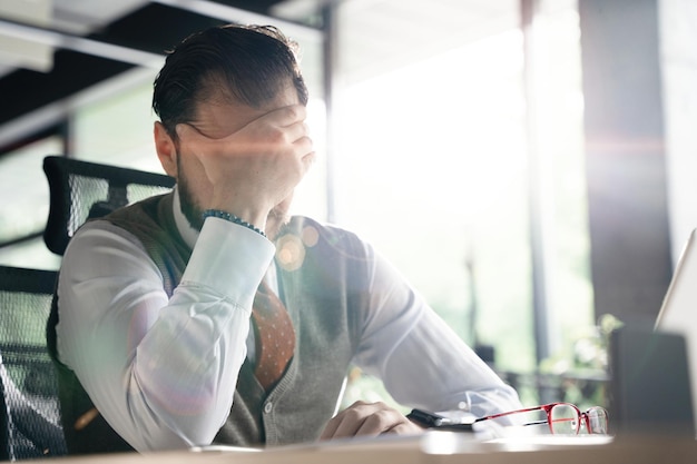 Feeling exhausted Frustrated middleaged beard man keeping eyes closed while sitting at his working place in office