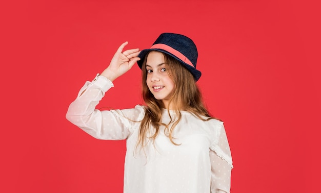 Feeling fancy Summer accessory collection Child long hair wear hat Accessories shop Outfit inspiration Individual style Girl wear hat red background Happy kid in hat Fashion accessory
