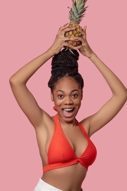 Feeling good. Young african american woman with a pineapple having fun