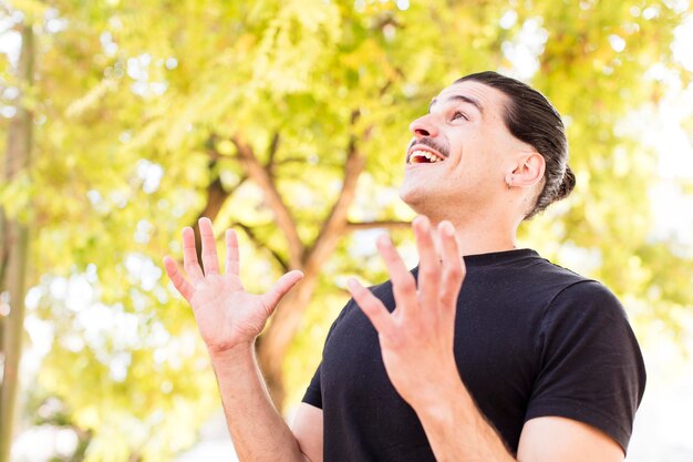 幸運と驚きの幸運を感じて、両手を空中に上げて勝利を祝う