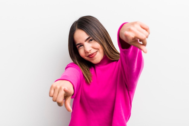 Feeling happy and confident pointing to camera with both hands and laughing choosing you