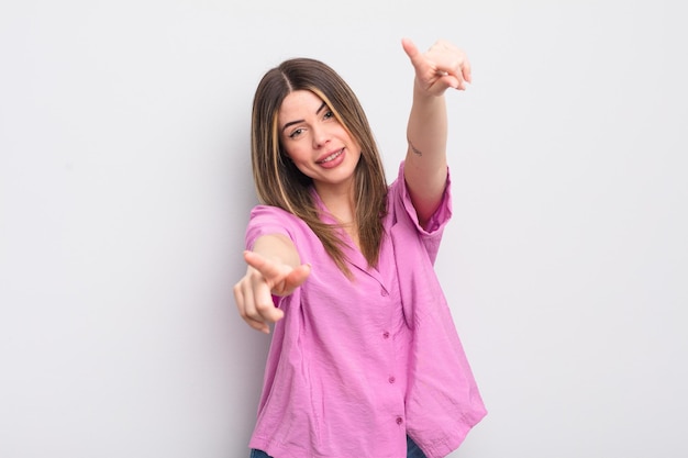 Feeling happy and confident pointing to camera with both hands and laughing choosing you