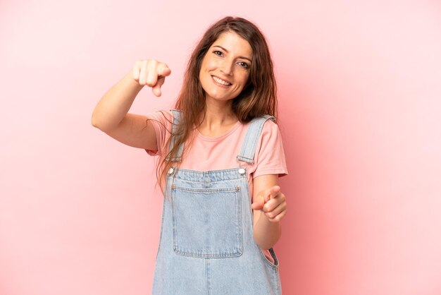 Feeling happy and confident pointing to camera with both hands and laughing choosing you